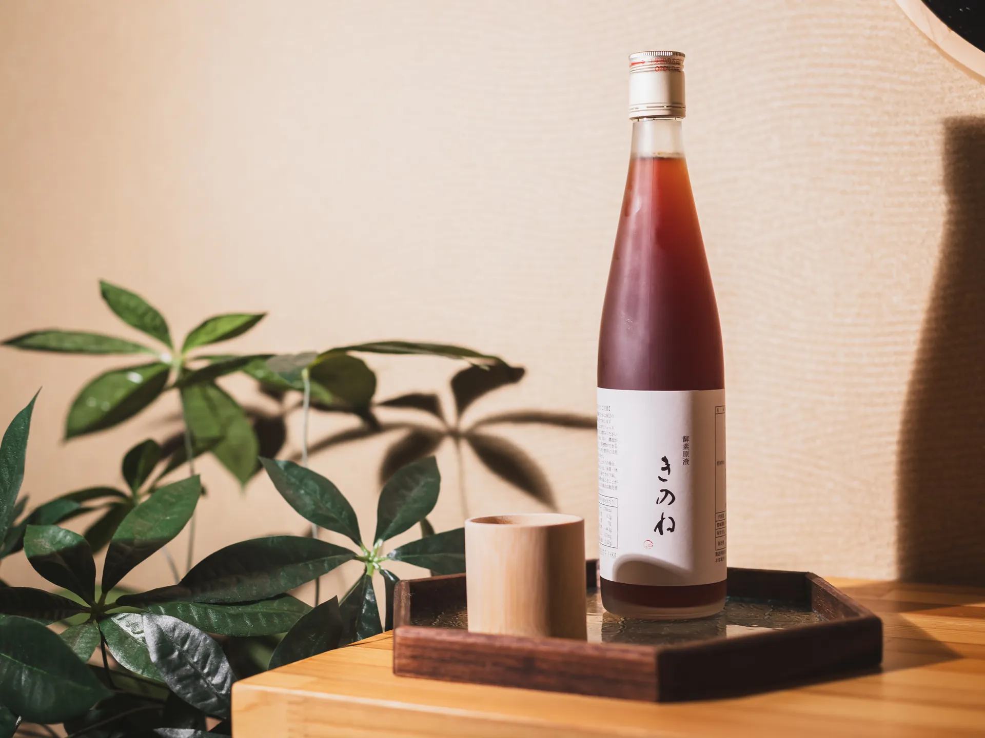 酵素原液「きのね」のボトルと木のカップ