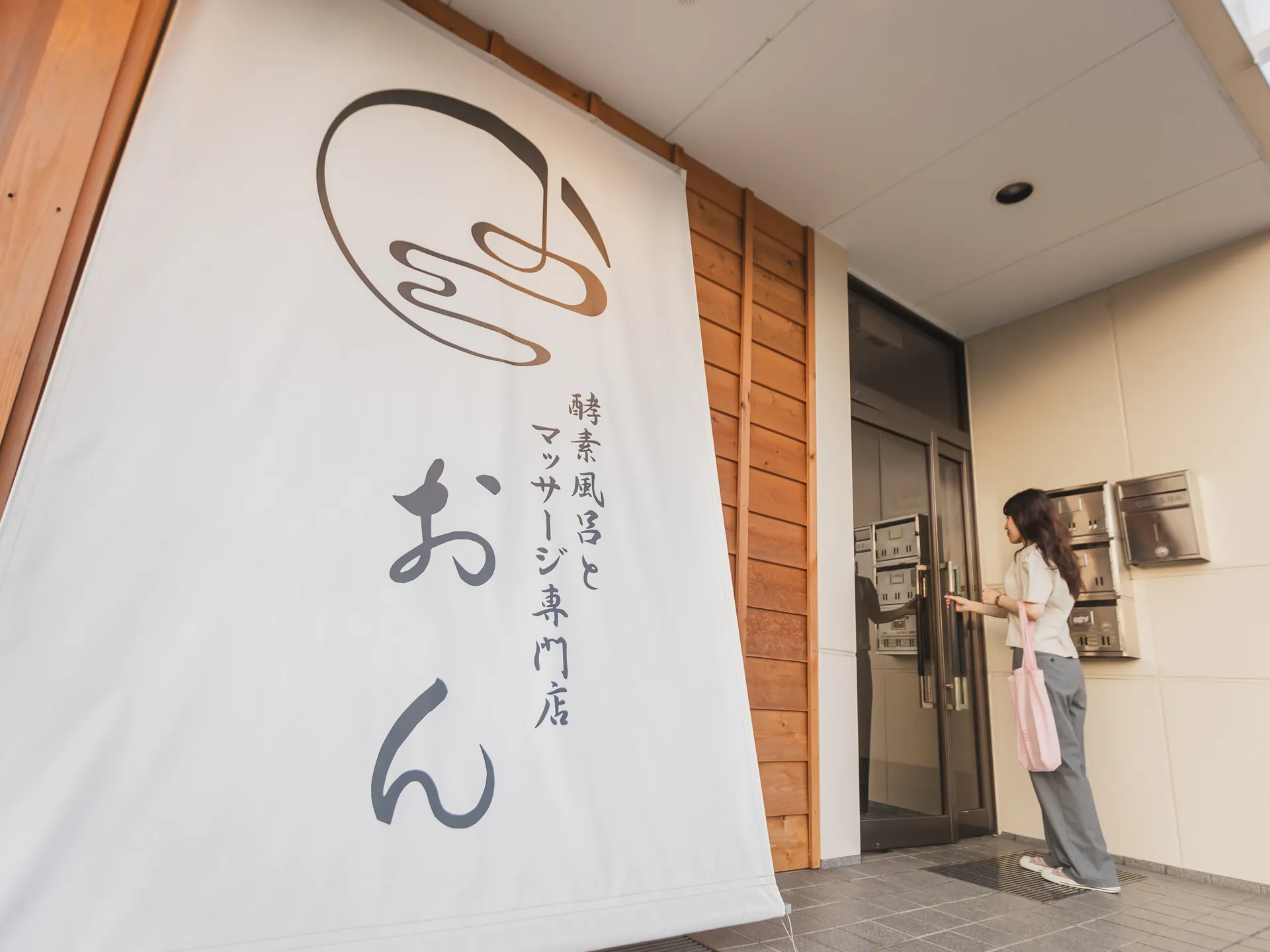 「酵素風呂とマッサージ専門店 おん」のロゴが入った白いのぼり